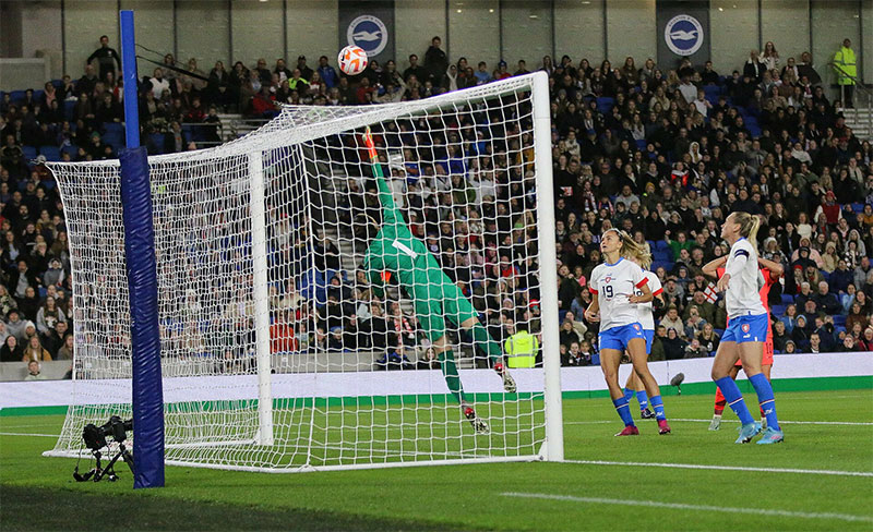 Goalkeeper diving to keep the ball away from goal.