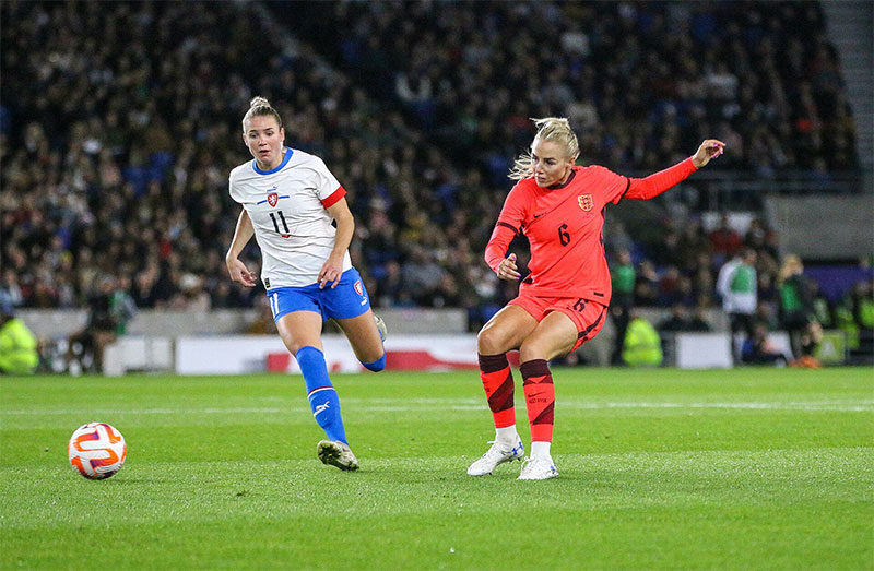 Centre-back Alex Greenwood (on the right wearing the orange shirt) passing the ball.