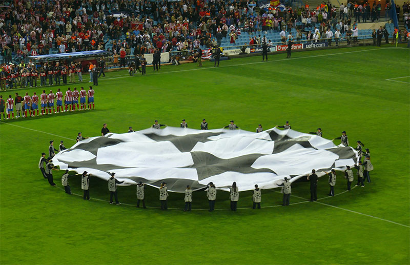 The two teams line up for the UEFA Champions League Anthem before each match and a flag of the Champions League 'starball' logo is waved in the centre circle.